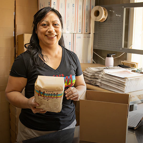 Person holding a bag of coffee in a warehouse setting