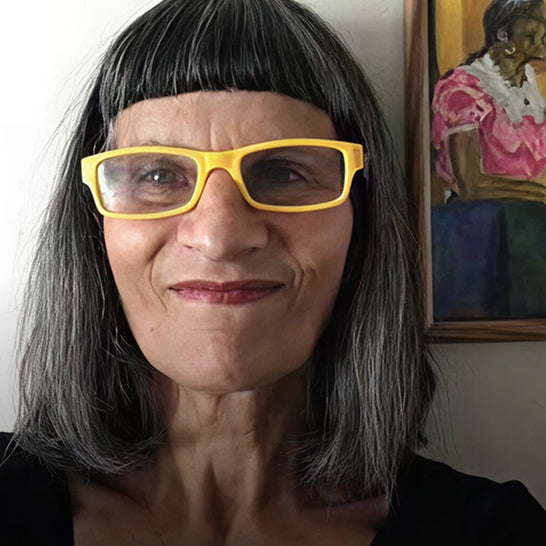 Person wearing yellow glasses with a painting in the background