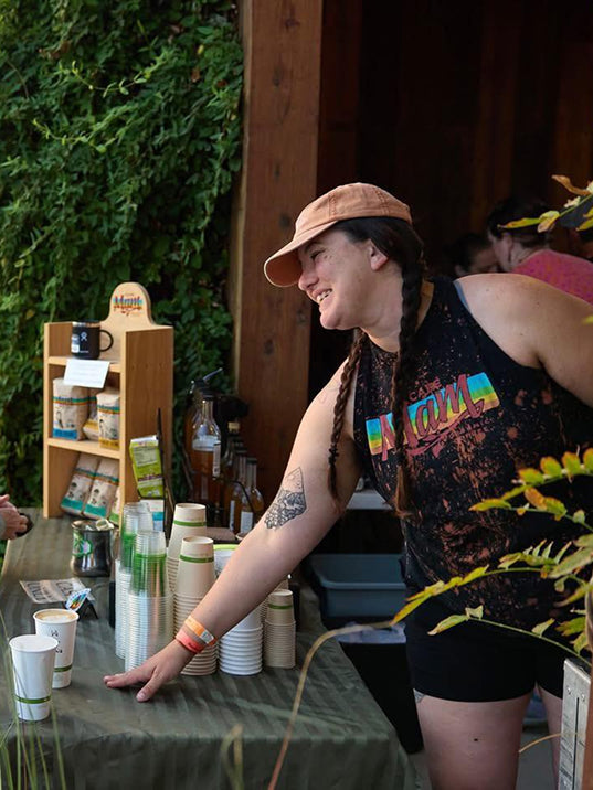Person at a outdoor event setting with drinks and snacks