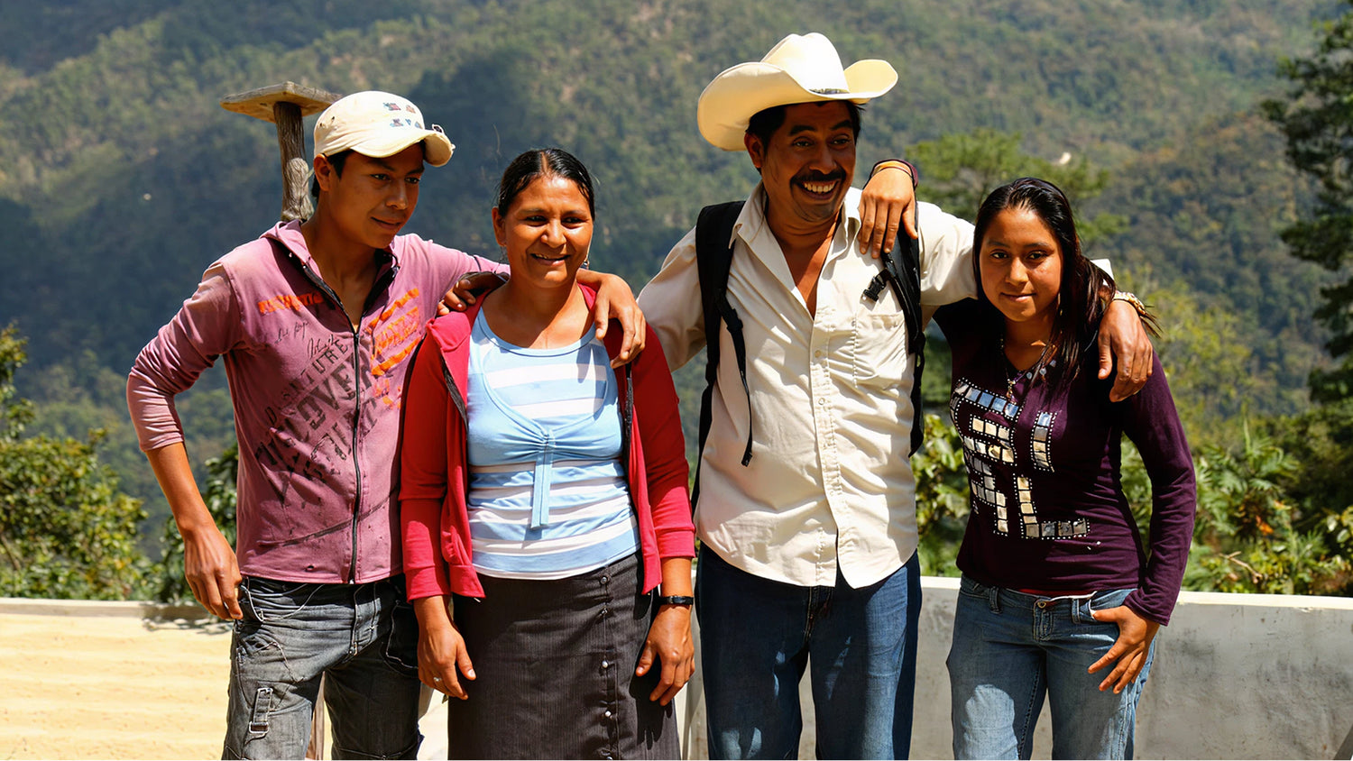 Four people posing together with a mountainous background
