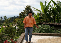 Coffee farmer drying his beans in the sun.